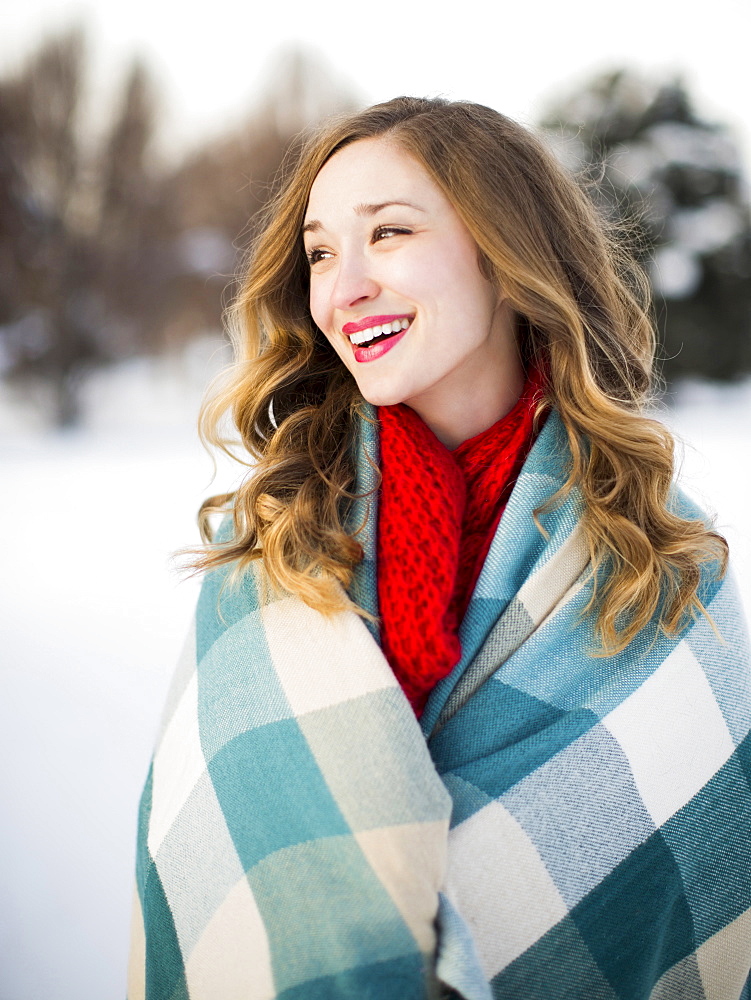 Portrait of woman wrapped in blanket smiling outdoors, Salt Lake City, Utah