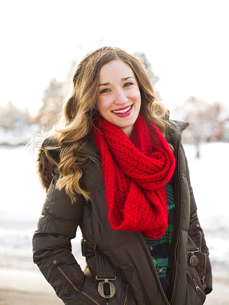 Portrait of woman wearing red scarf smiling outdoors