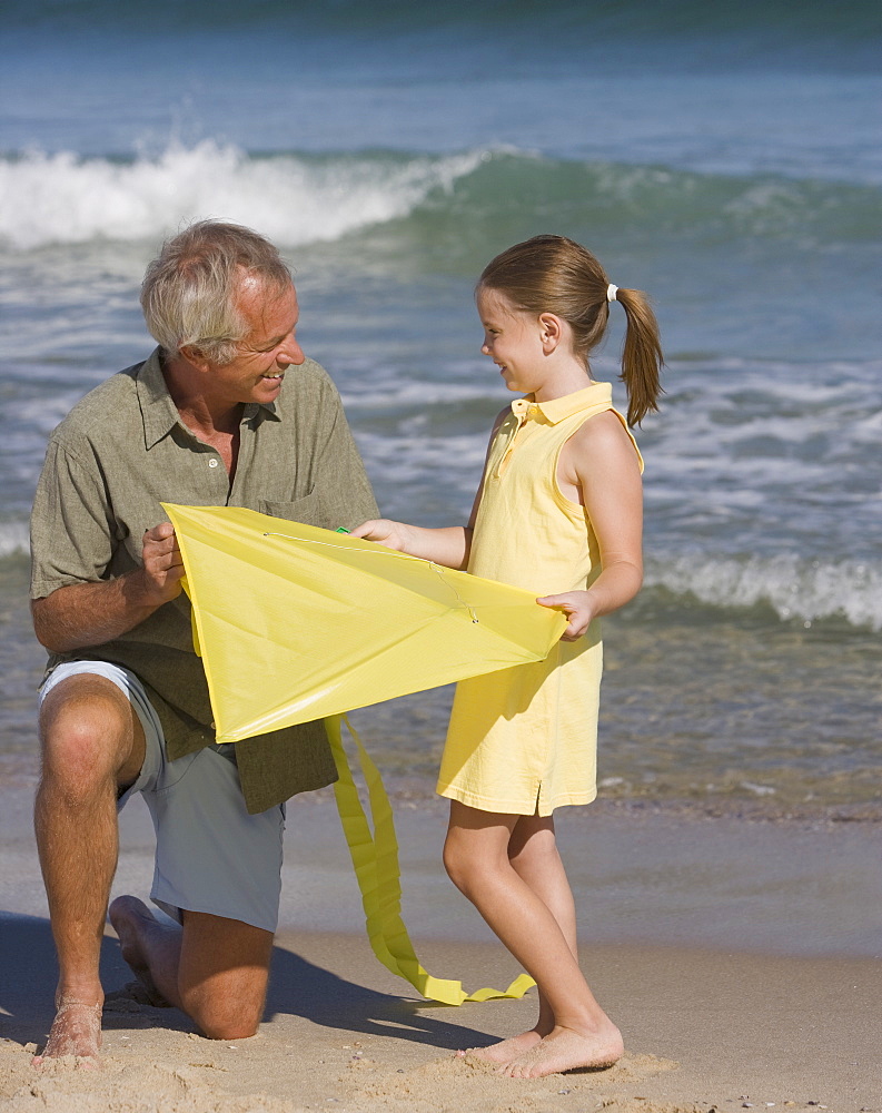 Father and daughter with kite at beach