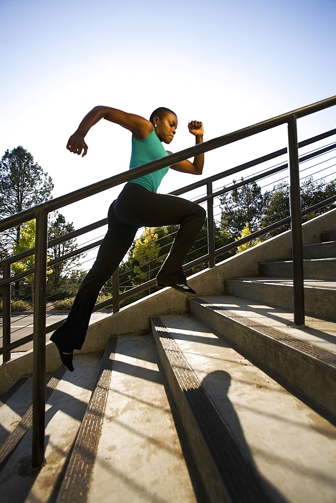 Woman running on steps, Berkeley, California, USA