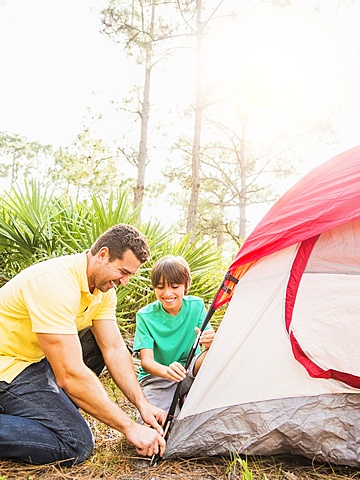 Father and son (12-13) setting up tent, Jupiter, Florida