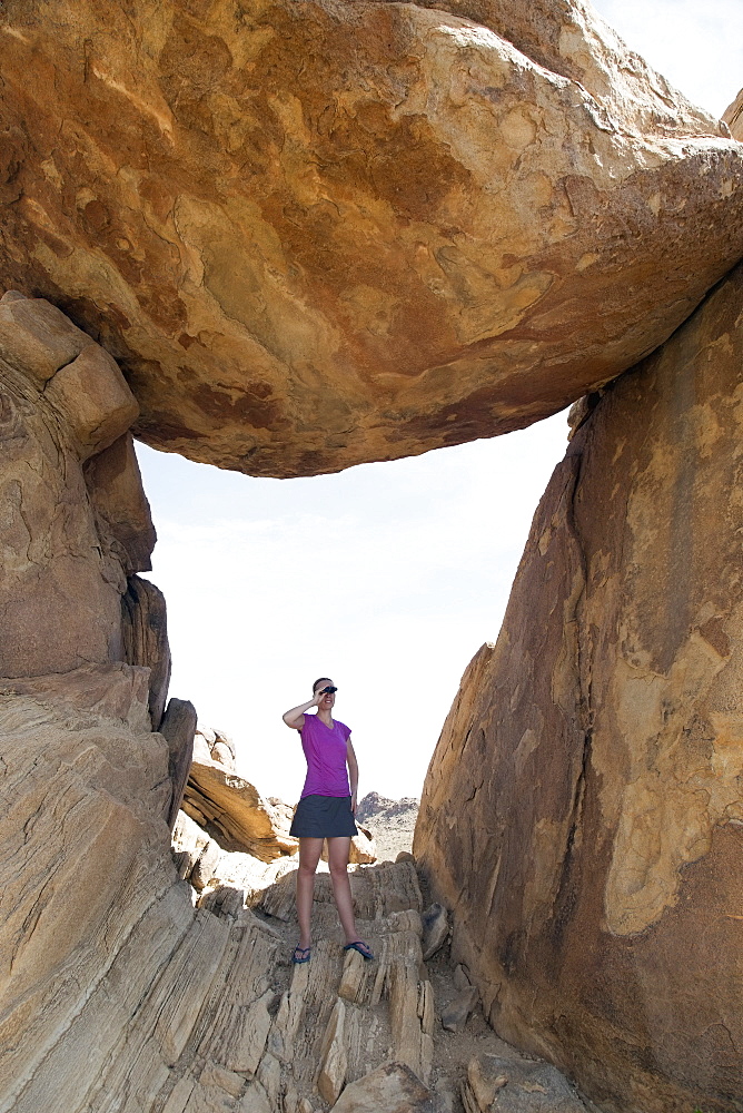 Woman visiting Balanced Rock, looking through binoculars, Balanced Rock Big Bend National Park Grapevine Hills, Texas 