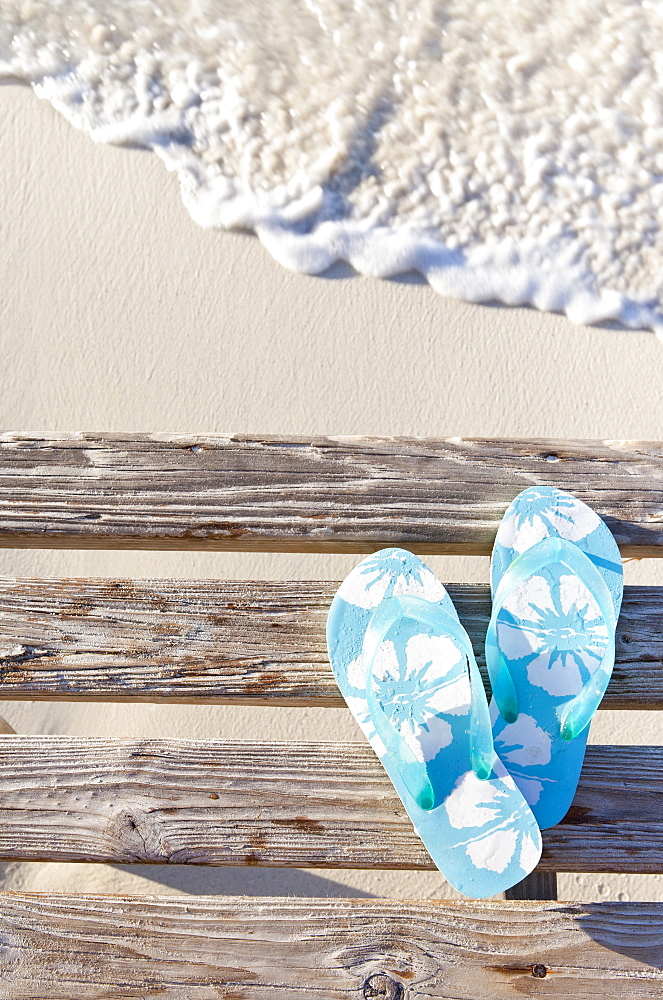 Flip flops on pier by sea