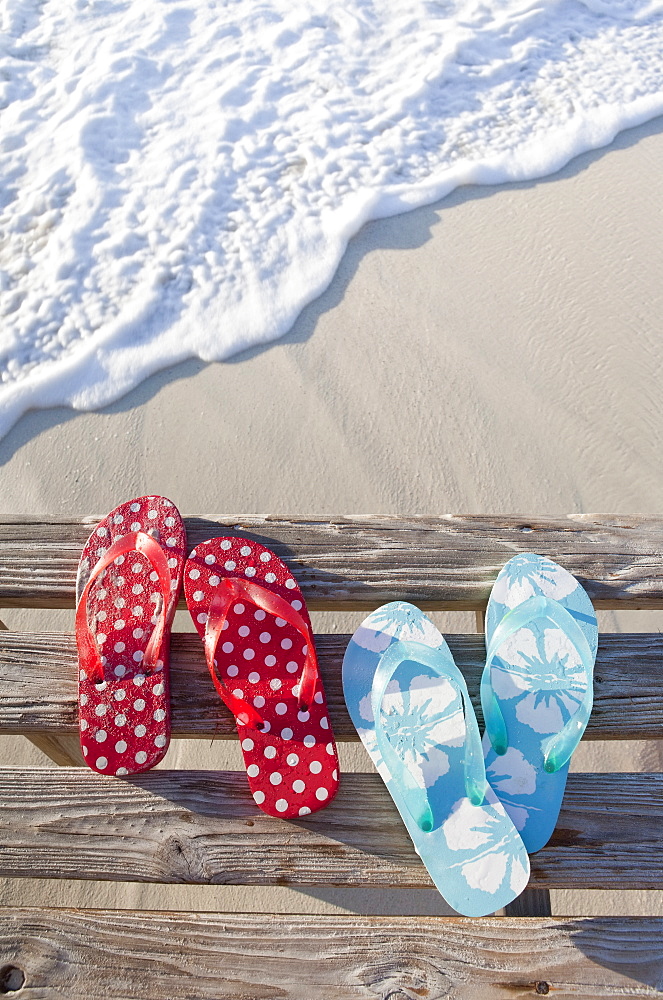 Flip flops on pier by sea