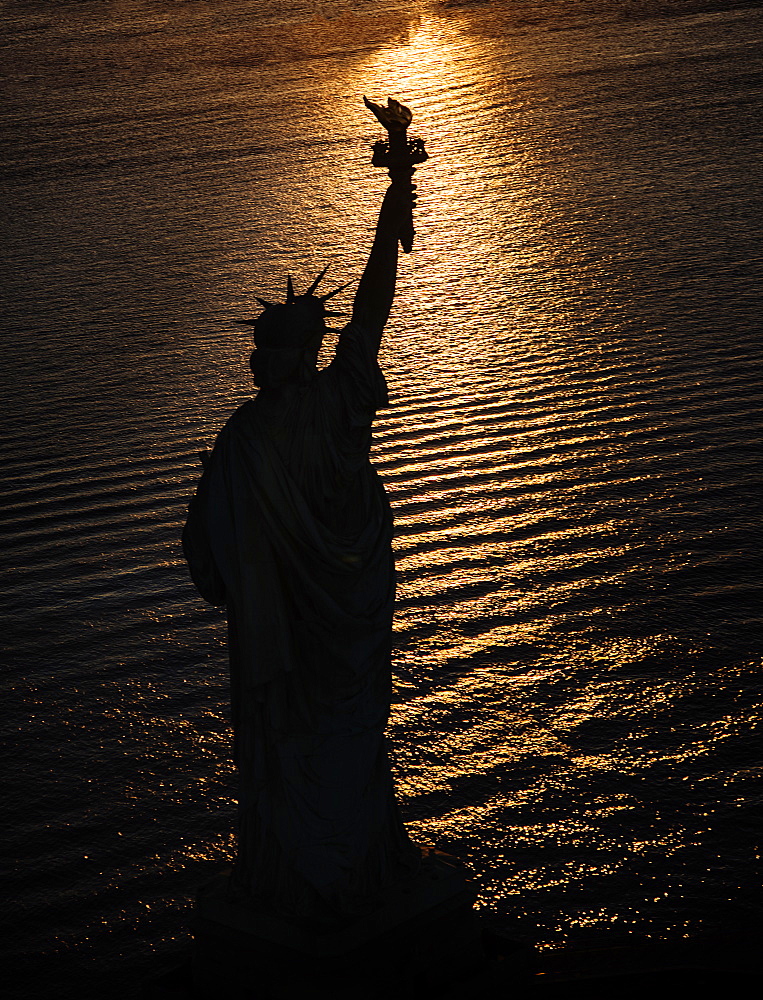 USA, New York State, New York City, Silhouette of Statue of Liberty at sunrise