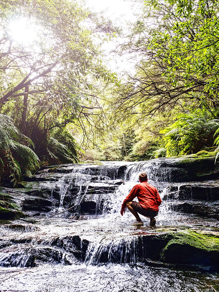 Australia, New South Wales, Katoomba, Man wading in Leura Cascade