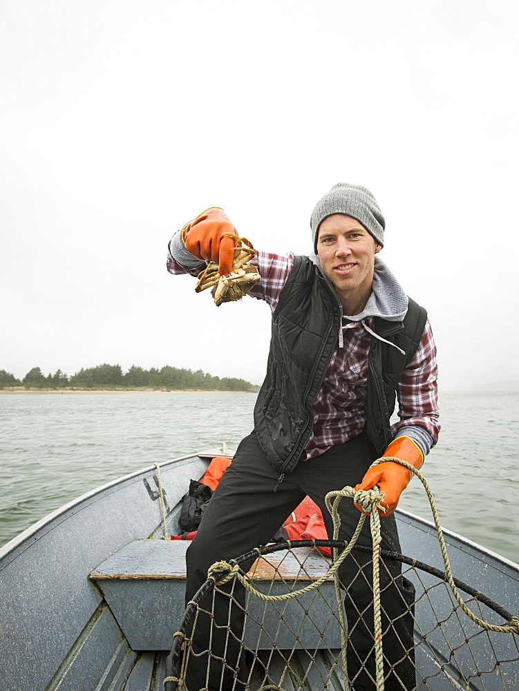 Portrait of man showing crab, Rockaway Beach, Oregon