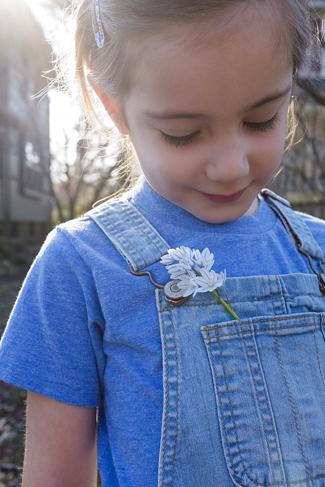 Girl with flower in overalls pocket