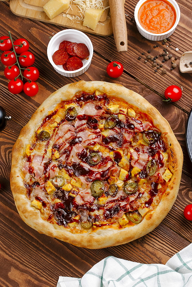 Pizza and ingredients on wooden table