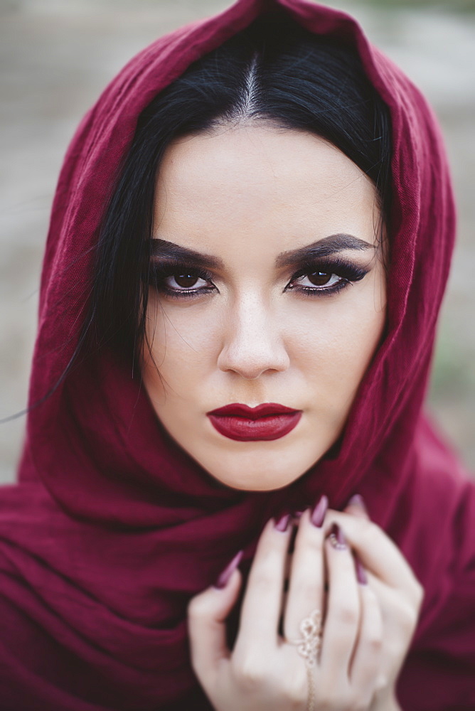 Portrait of young woman wearing red lipstick and headscarf