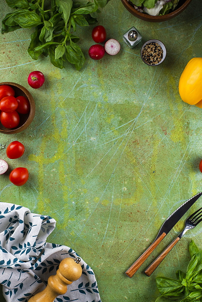 Tomatoes and basil on green surface