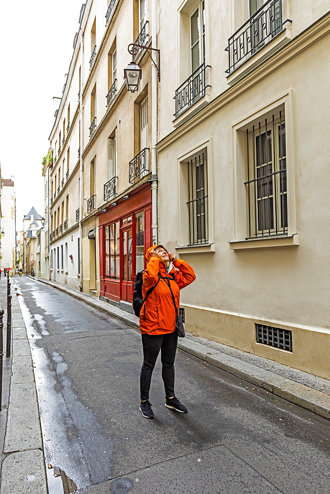 Woman wearing raincoat on street in Paris, France