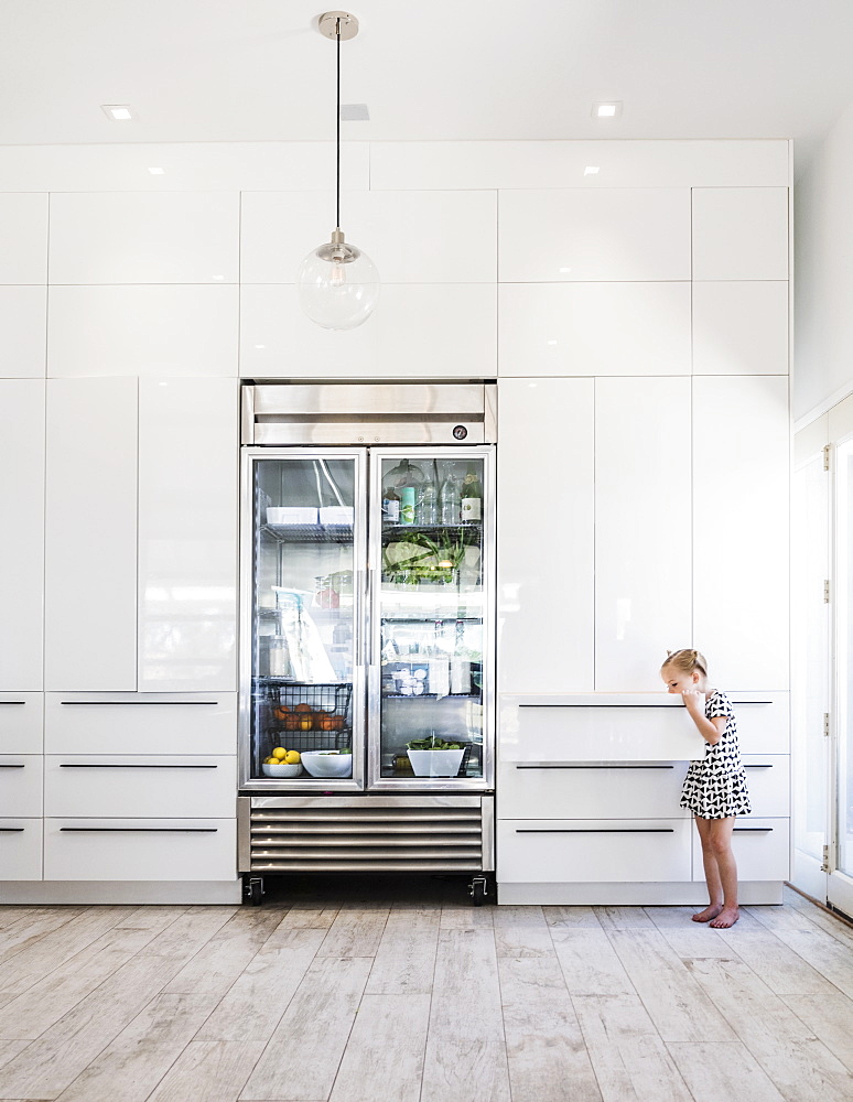 Girl opening drawer by refrigerator