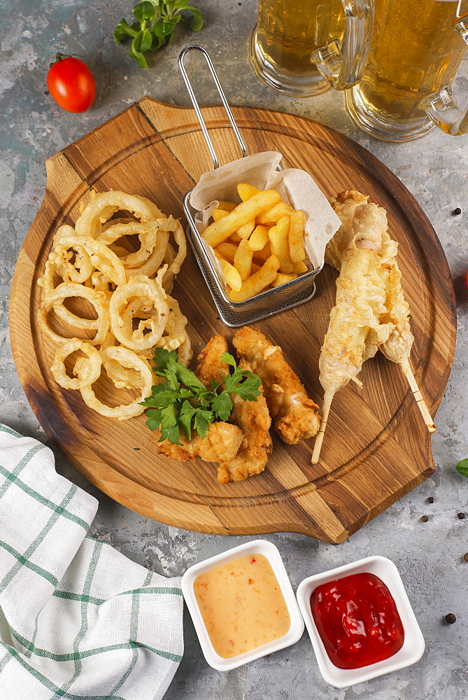 Deep fried snacks on cutting board with sauce