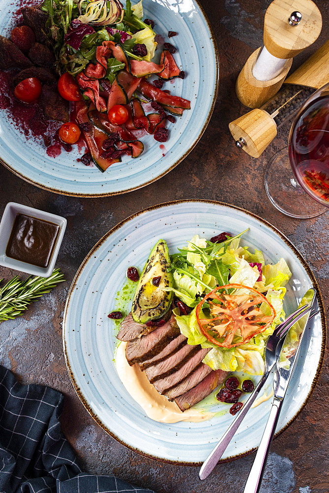 Two beef salads with red wine