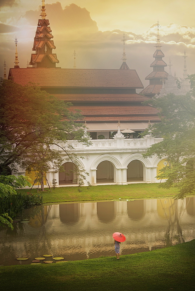 Woman holding umbrella by temple in Chiang Mai, Thailand