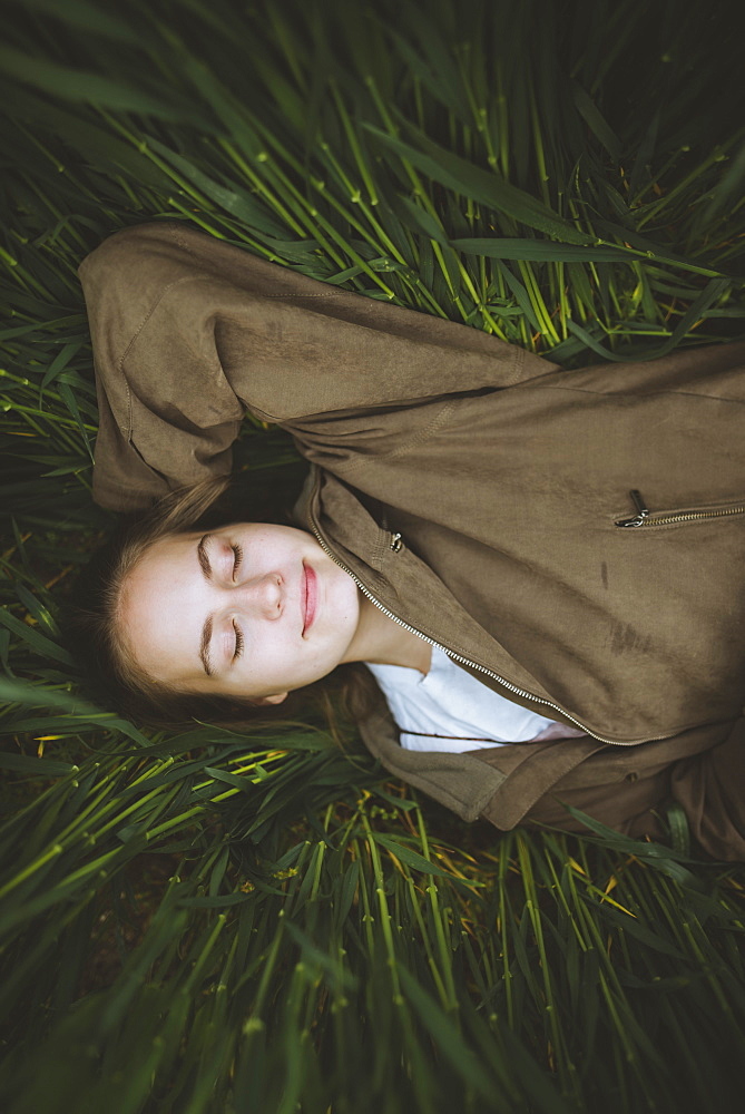 Smiling woman lying down in grass