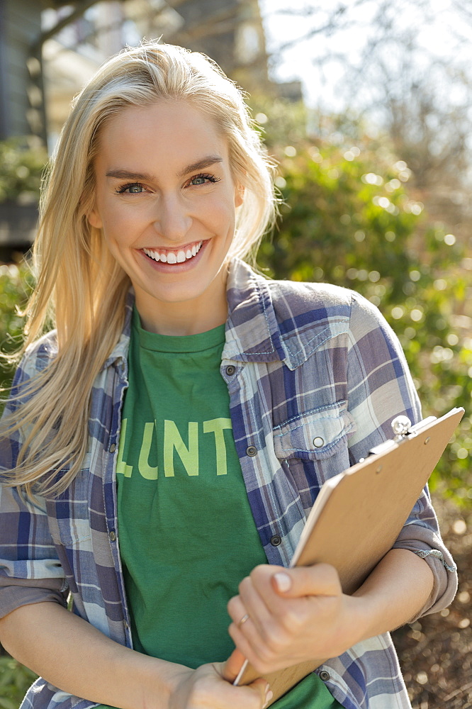 Smiling woman holding clipboard