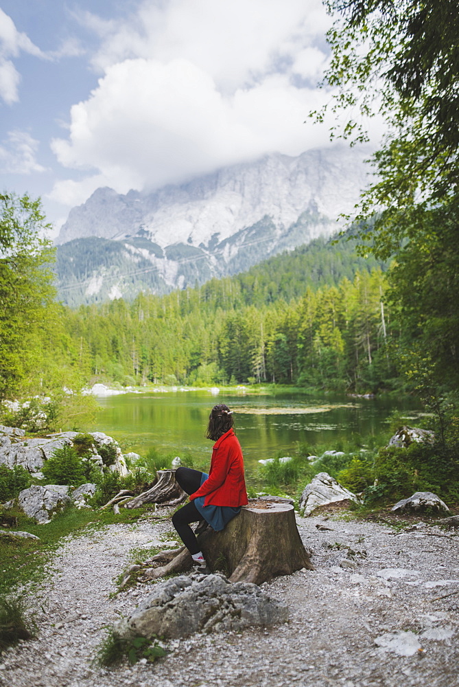 Germany, Bavaria, Eibsee, Woman sitting by Frillensee lake