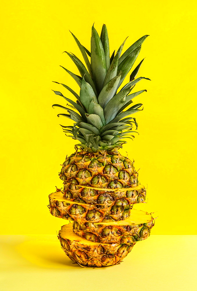 Sliced pineapple against yellow background