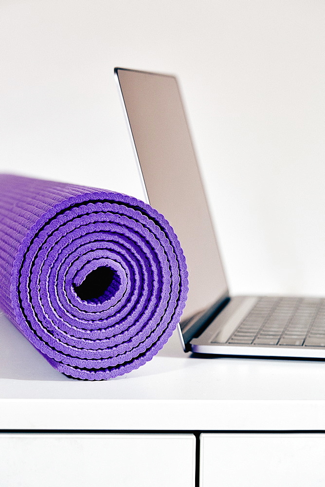 Yoga mat with laptop on table