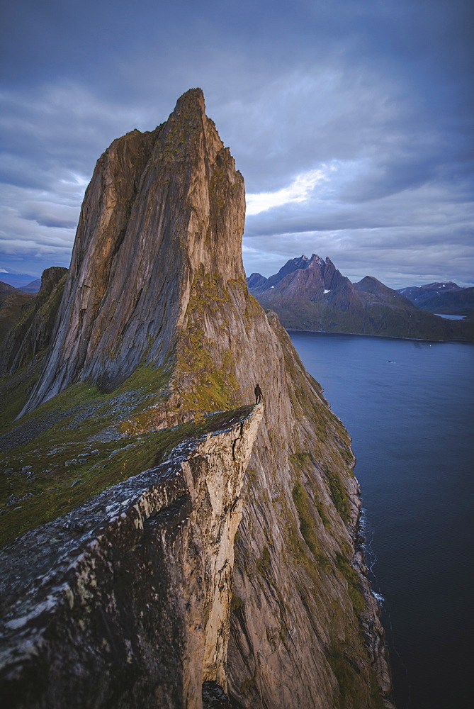 Norway, Senja, Man standing on cliff edge near Segla mountain