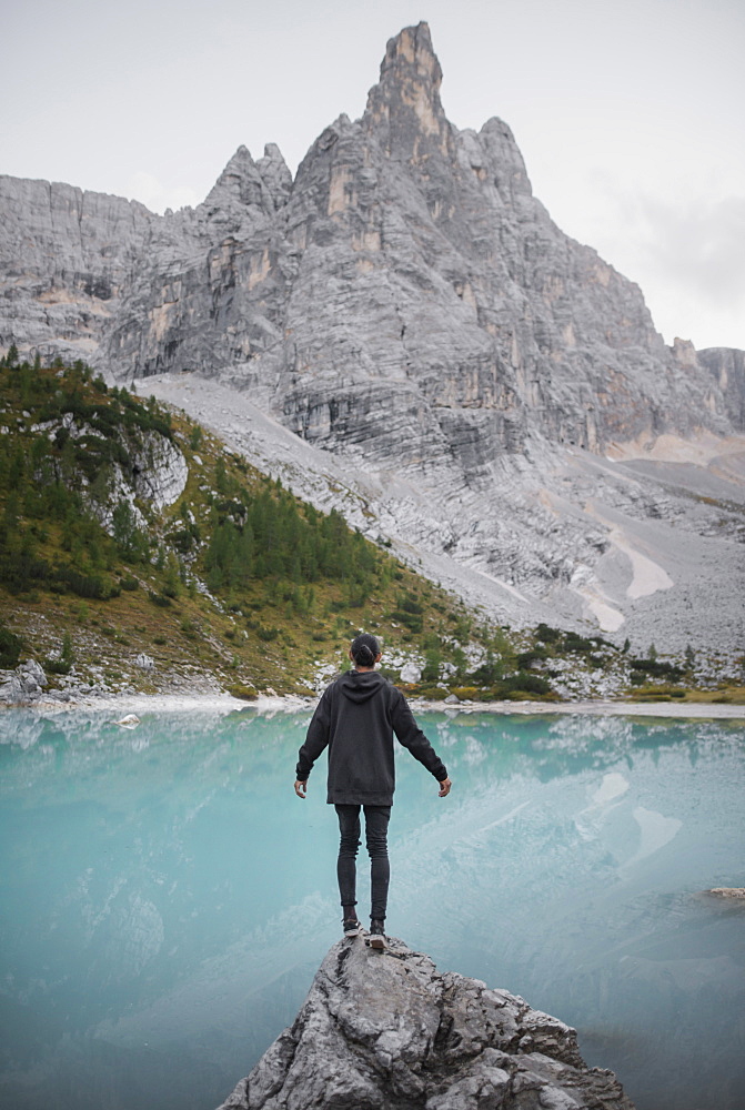 Italy, South Tyrol, Cortina d Ampezzo, lake Sorapis, Man standing on rock looking at lake