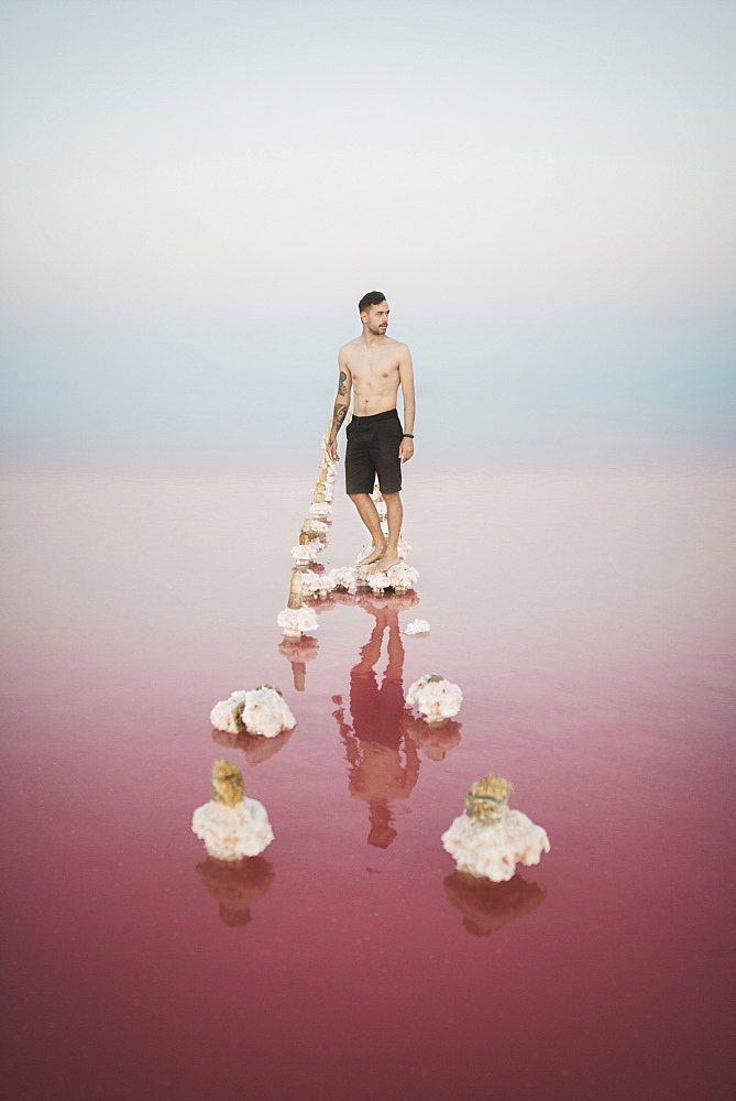 Ukraine, Crimea, Man standing on salt crystal in salt lake