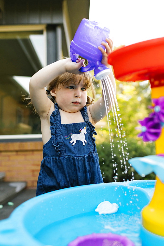 Toddler girl (2-3) playing with water in garden