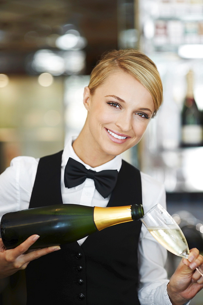 Waitress pouring champagne into champagne flute