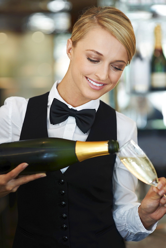 Waitress pouring champagne into champagne flute