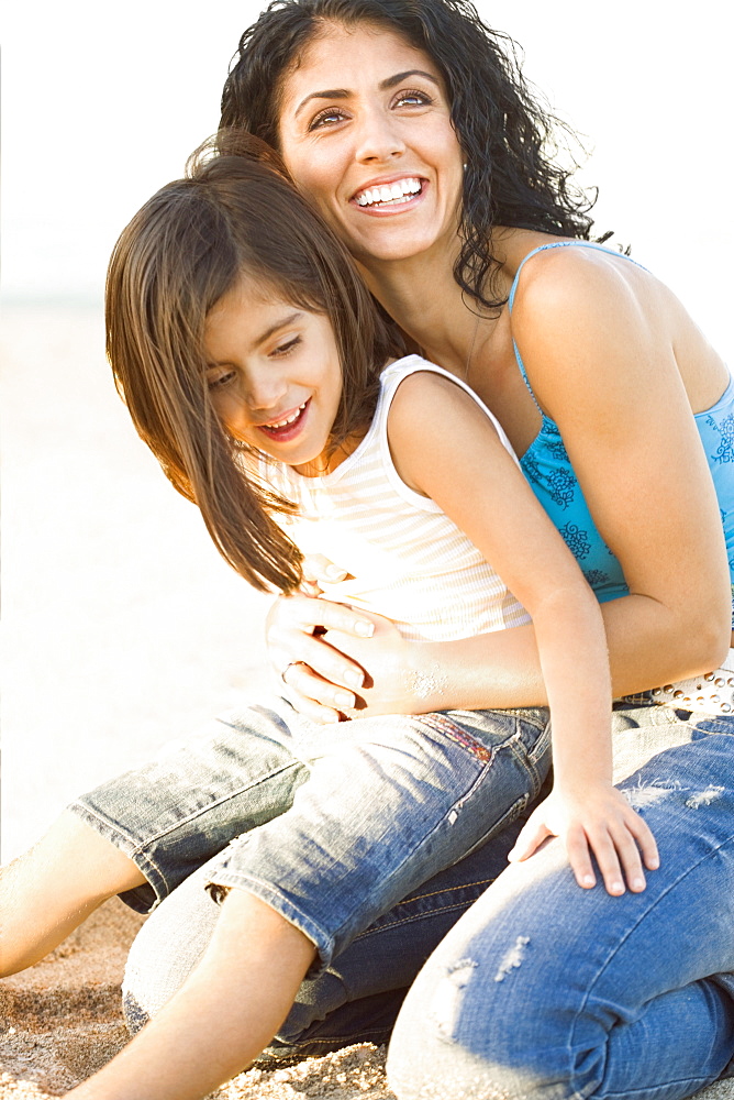 Mixed race mother holding daughter in lap