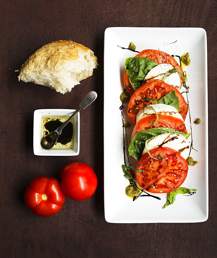 Sliced vine tomatoes and mozzarella with basil and bread