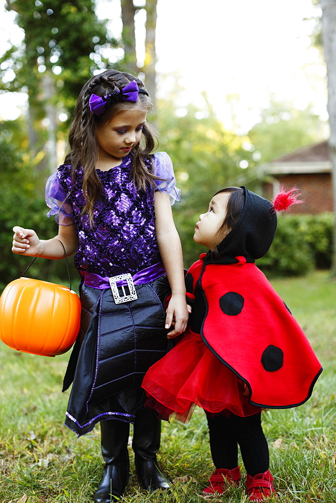 Two girls with trick or treat bucket