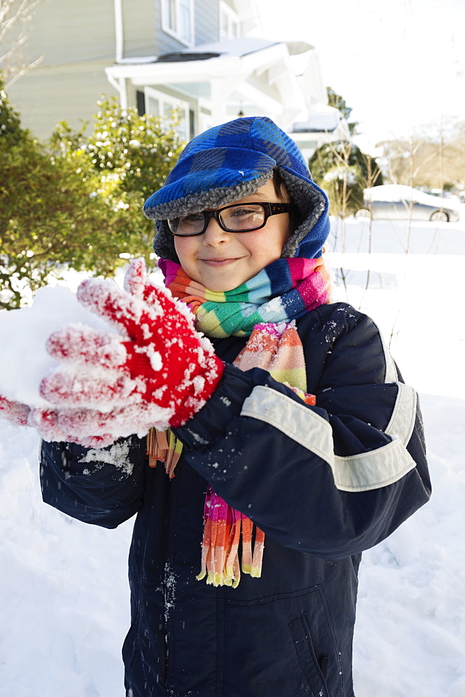 Boy making snowball, smiling