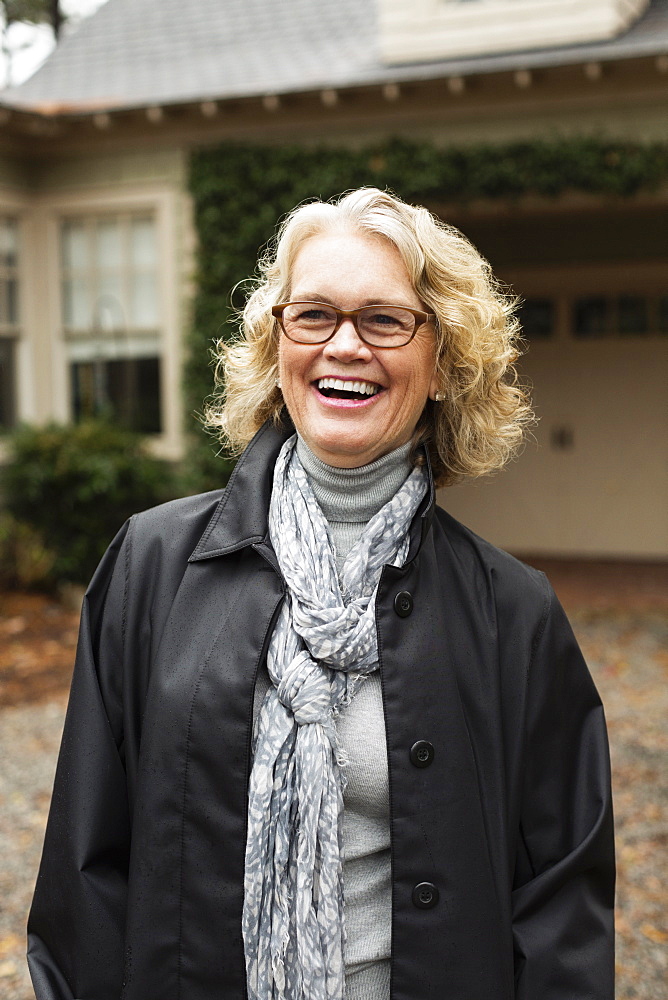 Portrait of contented senior woman outside house