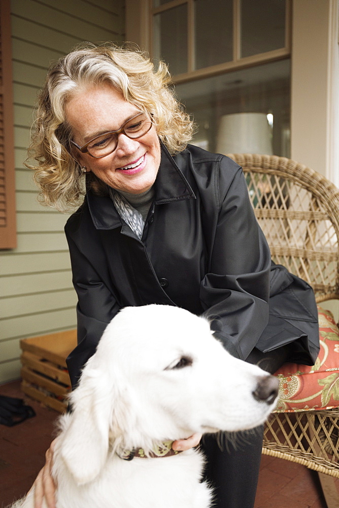 Senior woman sitting in porch with dog