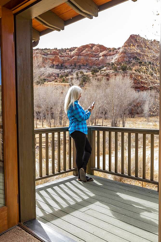 USA, Utah, Escalante, Woman on deck of home in canyon in Grand Staircase-Escalante National Monument