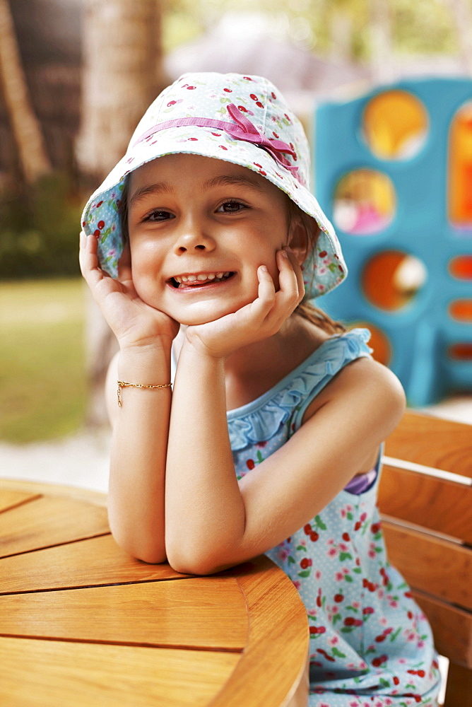 Portrait of smiling girl (6-7) sitting at table