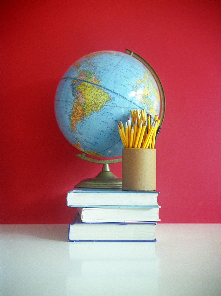 Still life of books, pencils, and globe