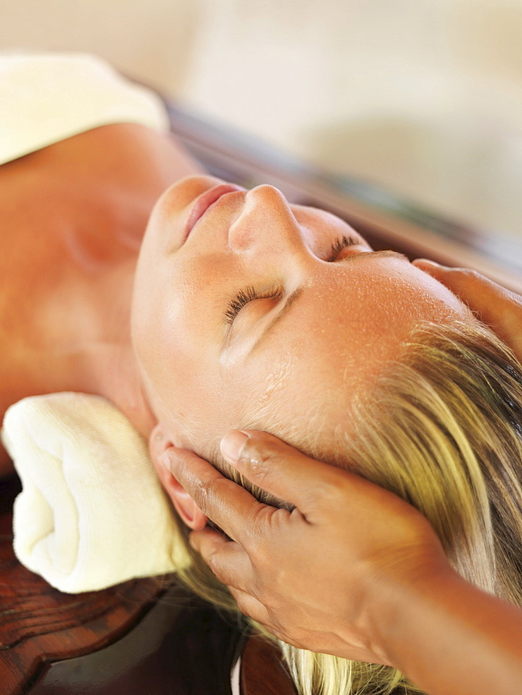 Mid adult woman receiving head massage