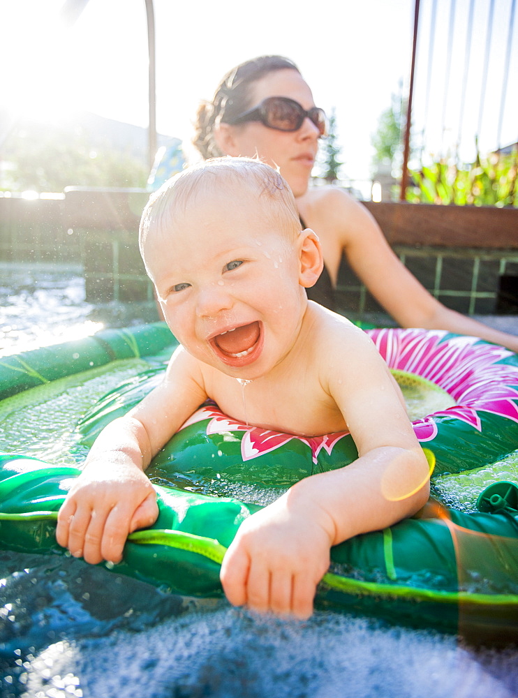 Baby boy (18-23 months) playing in swimming pool with his mother, USA, Utah, Park City 