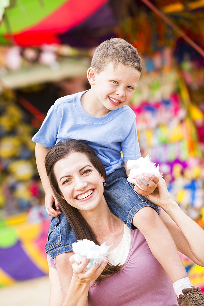 Happy mother with son (4-5) in amusement park eating cotton candy, USA, Utah, Salt Lake City 