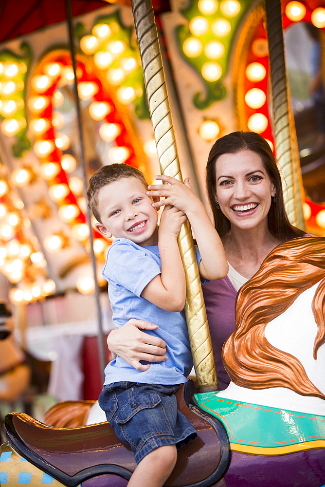 Mother and son (4-5) on carousel in amusement park, USA, Utah, Salt Lake City 