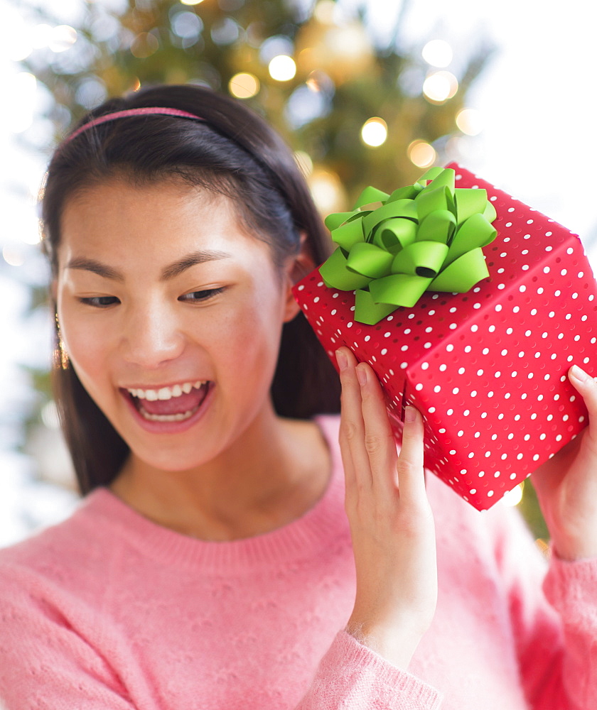 Front view of teenage girl ( 16-17 years) holding Christmas gift