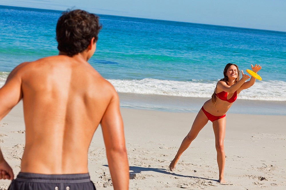 Woman catching a Frisbee on the beach