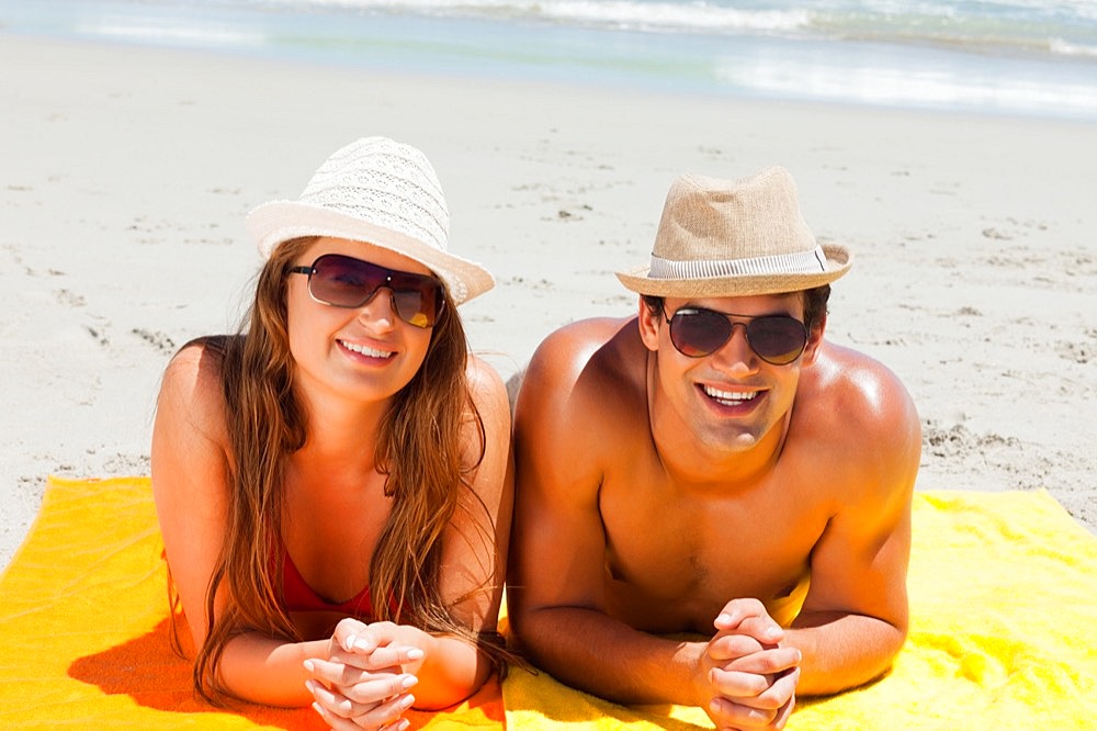 Portrait of a smiling couple being tanning