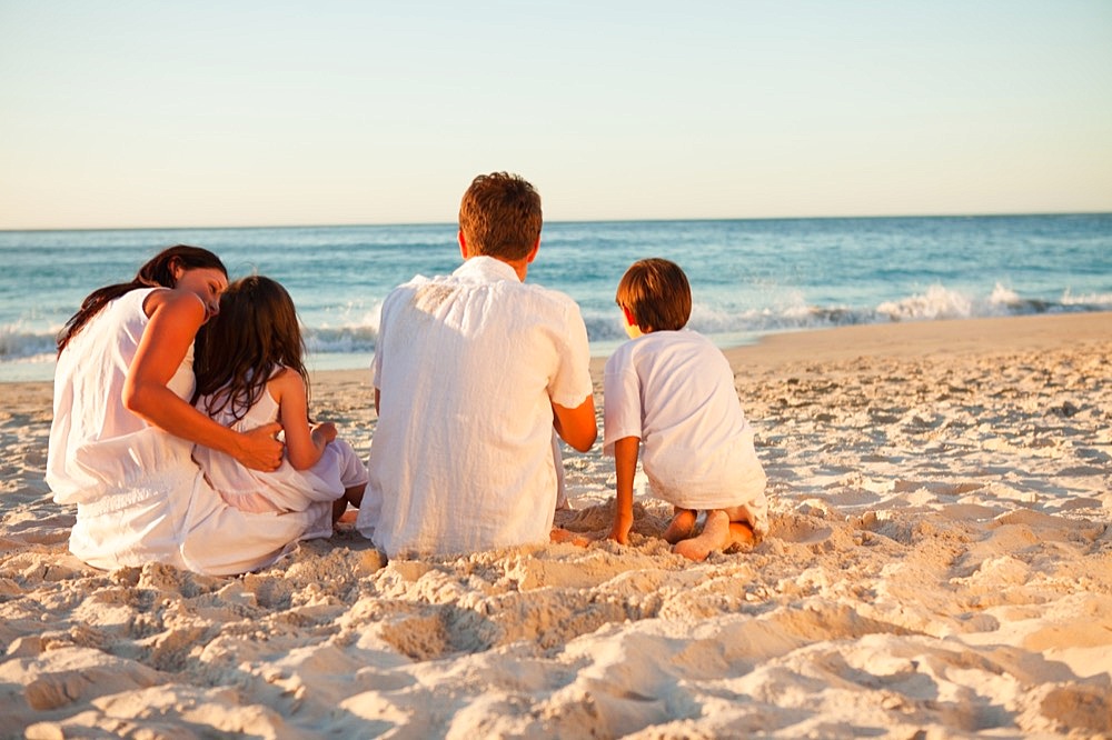 Back view of family sitting on the beach