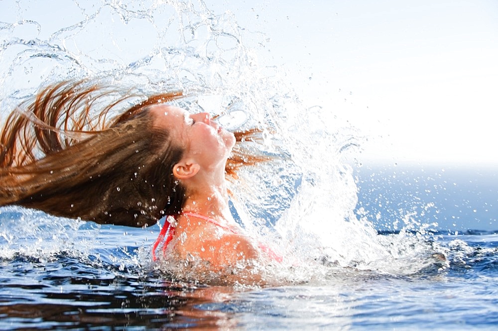 Beautiful woman raising her head out of the water