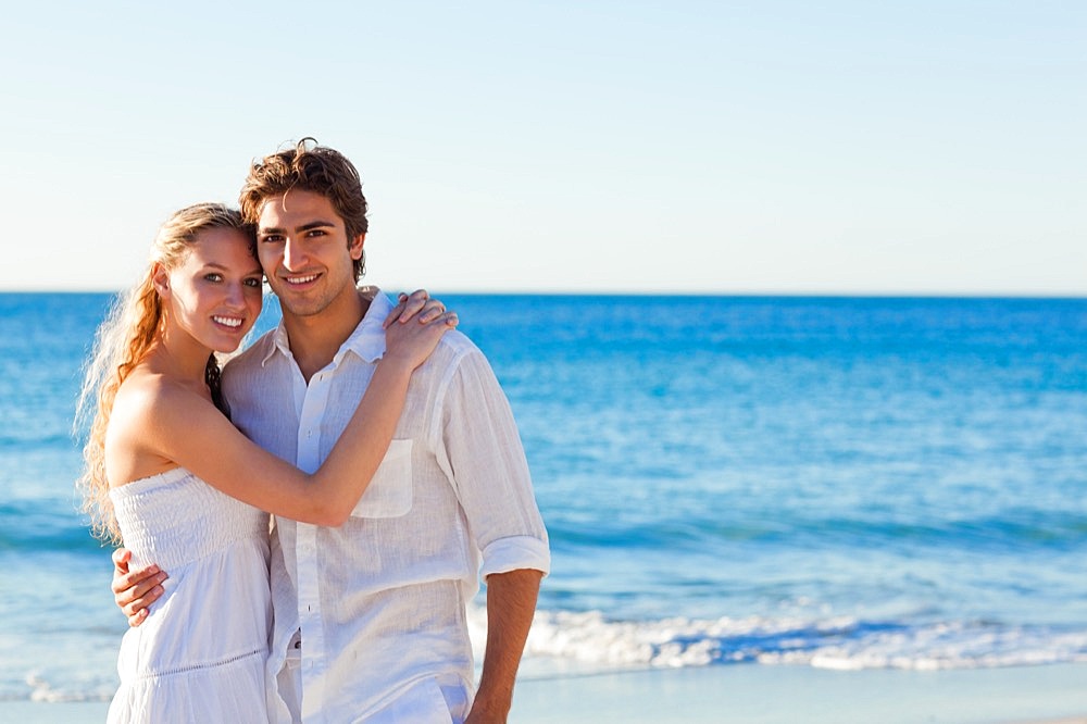 Happy couple standing on the beach